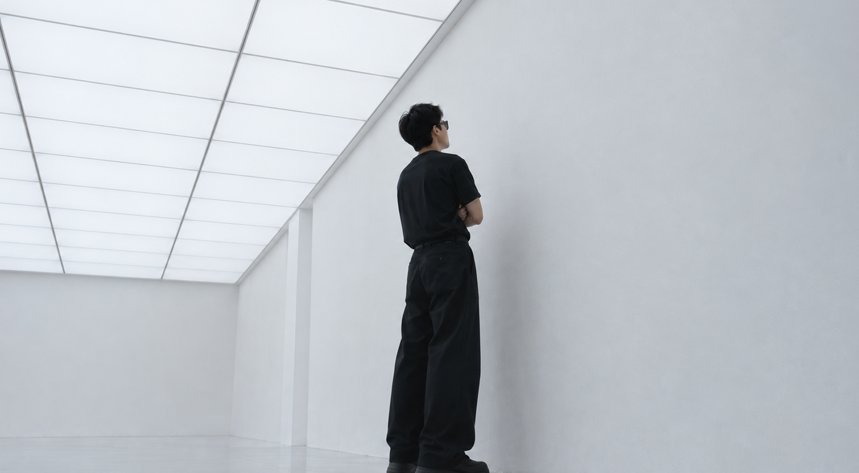 A visitor in AR glasses looking up at a white gallery wall