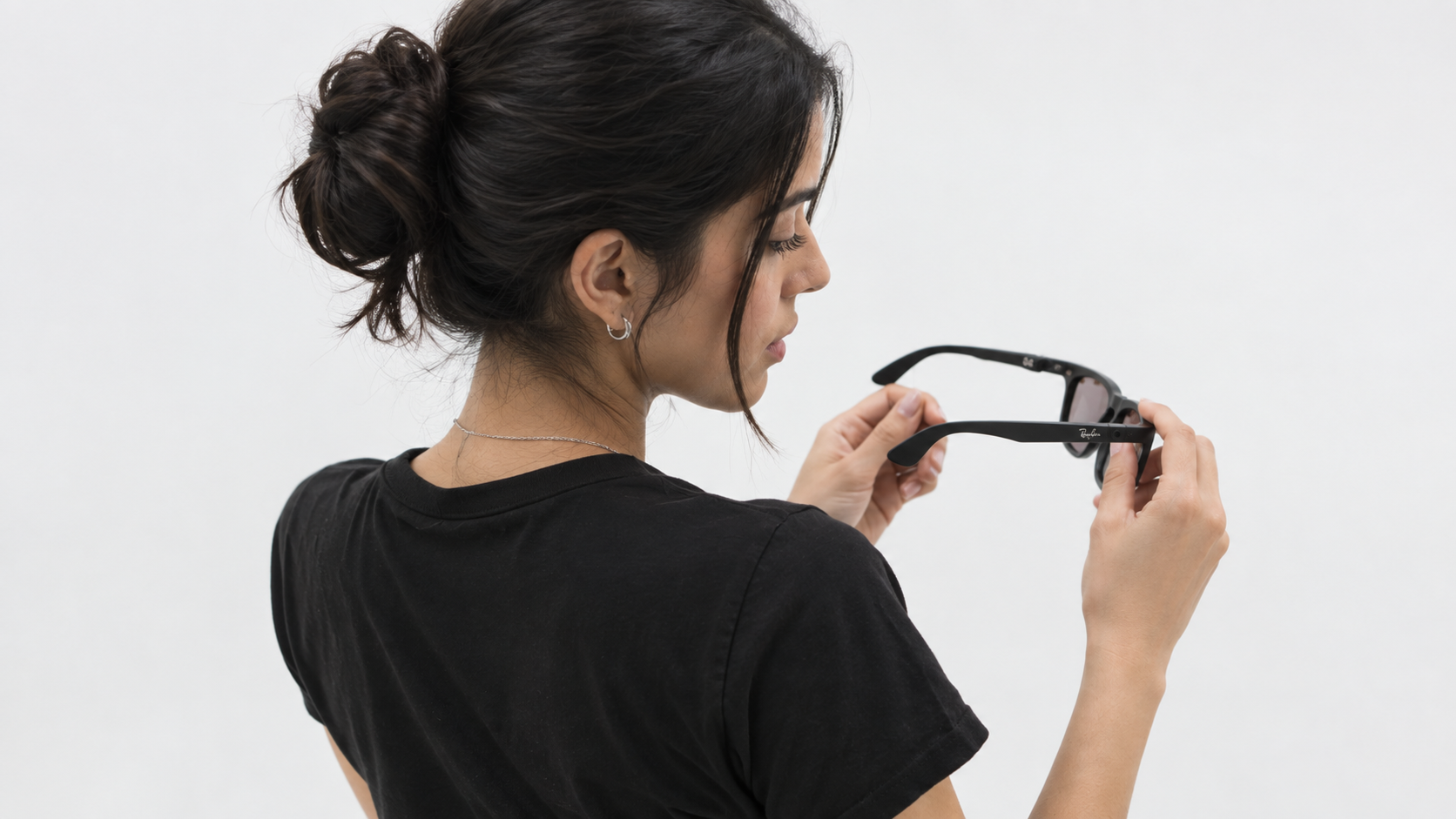 A user examining a pair of Ray-Ban smart glasses