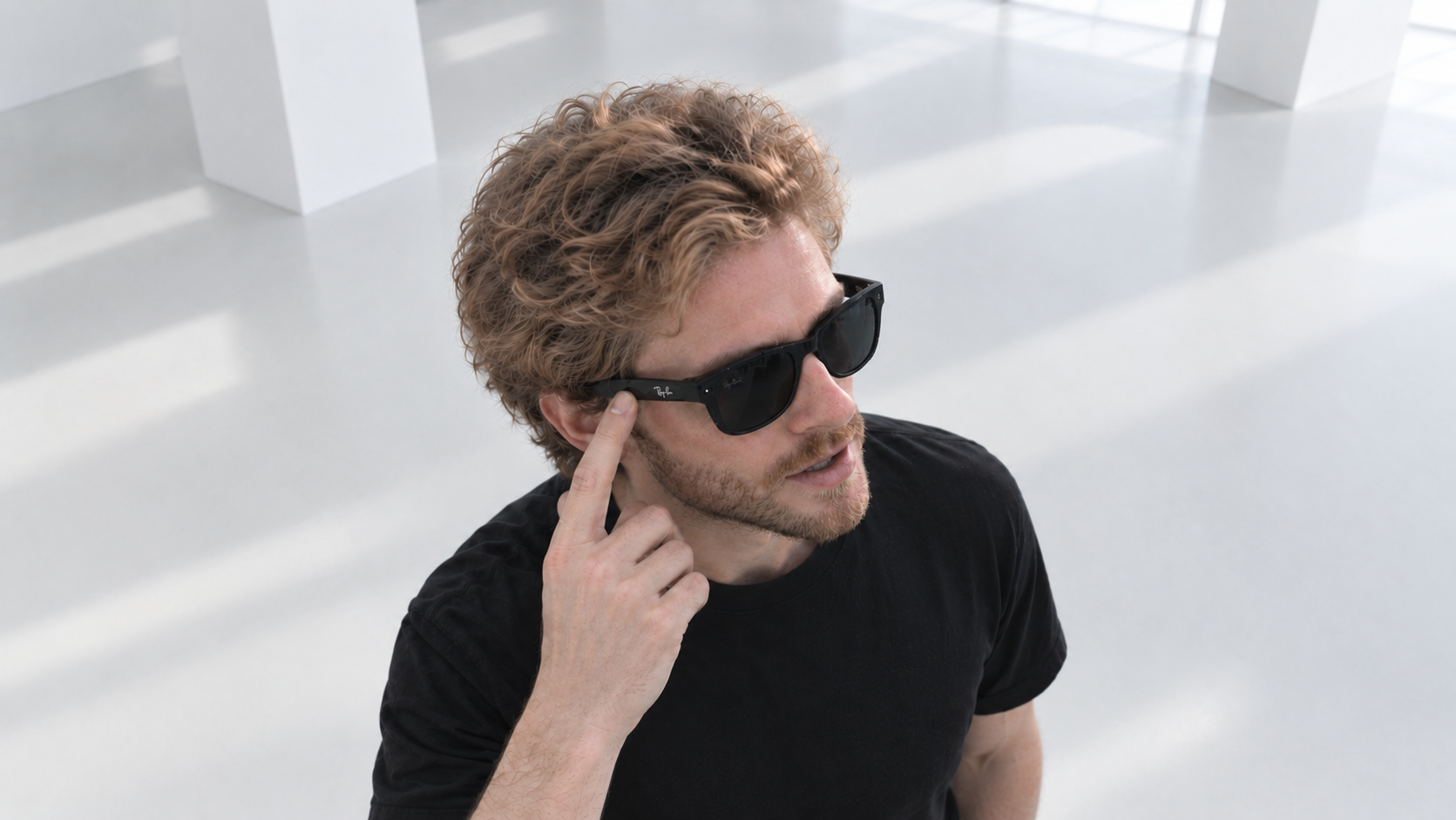 A user tapping the temple of Ray-Ban smart glasses while speaking